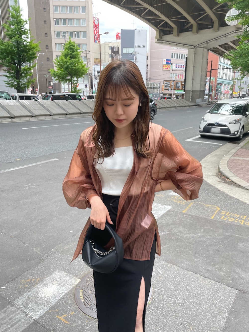 ブラック系のハンドバッグ、ブラック系のサンダル、ブラウン系のシャツ/ブラウスを着用したレディースの春コーディネートの4枚目の写真