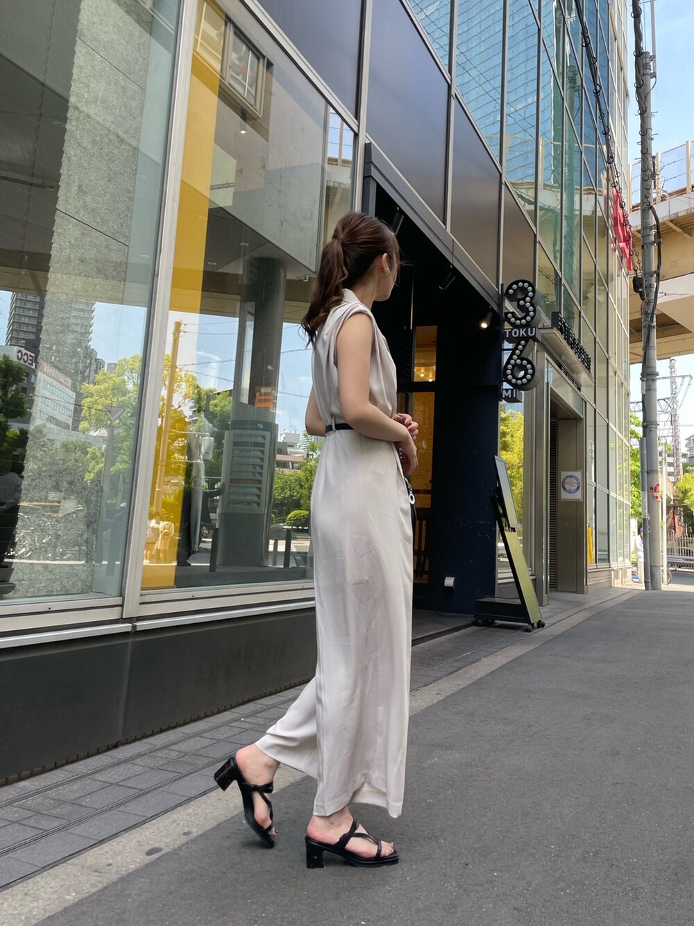 ホワイト系のつなぎ/オールインワン、ブラック系のサンダル、ブラック系のショルダーバッグを着用したレディースの春コーディネートの2枚目の写真