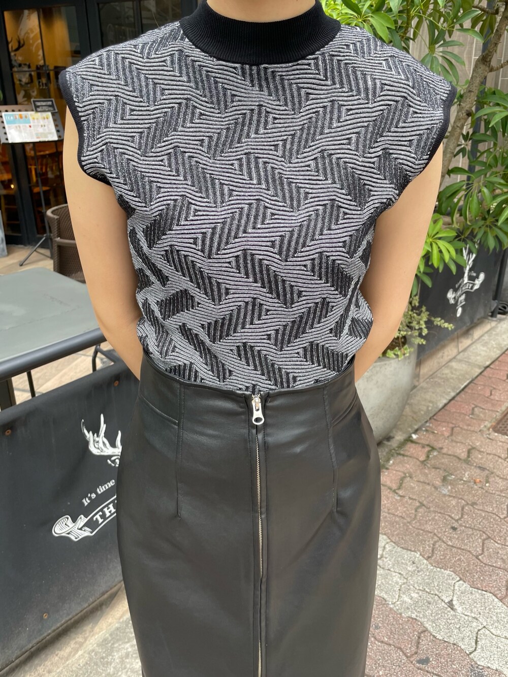 ブラック系のニット/セーター、ブラック系のスカート、ブラック系のブーツを着用したレディースの秋コーディネートの6枚目の写真