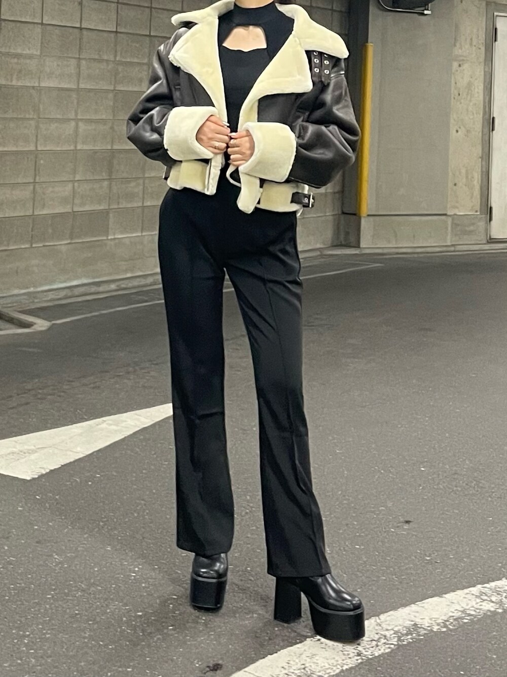 ブラック系のブーツ、ブラック系のスラックス、ブラック系のニット/セーターを着用したレディースの夏コーディネートの4枚目の写真