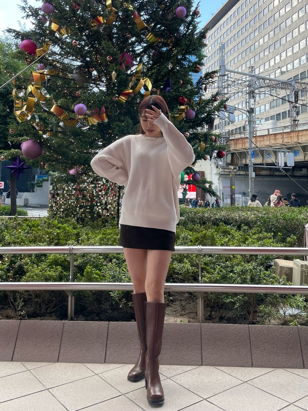 ホワイト系のニット/セーター、ブラウン系のスカート、ブラウン系のブーツを着用したレディースの秋コーディネートの2枚目の写真