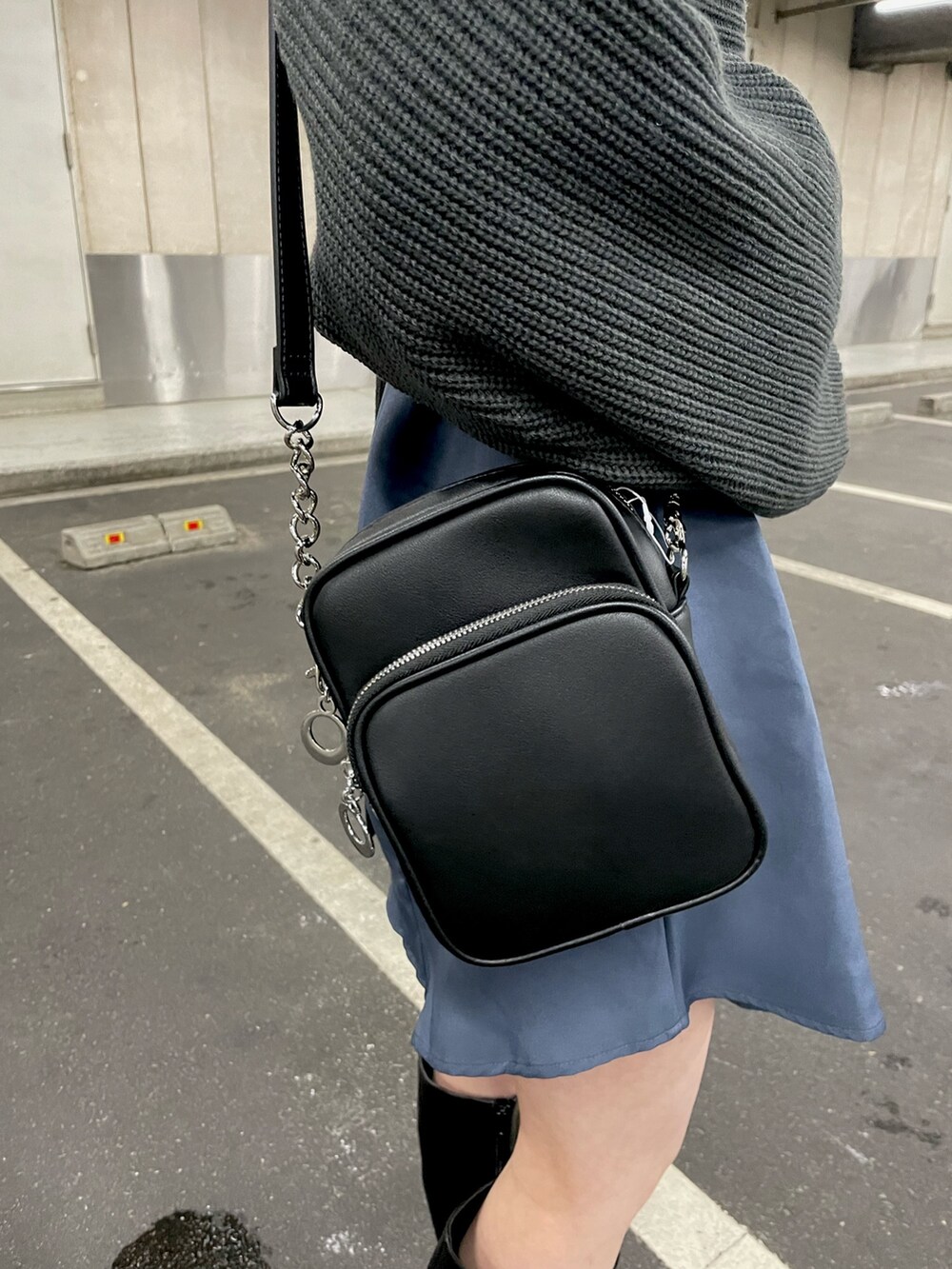 グレー系のワンピース、ブラック系のショルダーバッグ、ブラック系のブーツを着用したレディースの冬コーディネートの6枚目の写真
