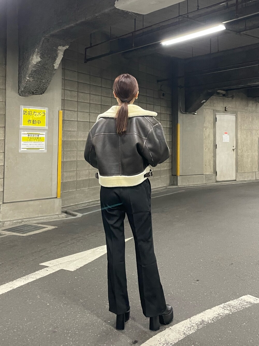 ブラック系のブーツ、ブラック系のスラックス、ブラック系のニット/セーターを着用したレディースの夏コーディネートの3枚目の写真