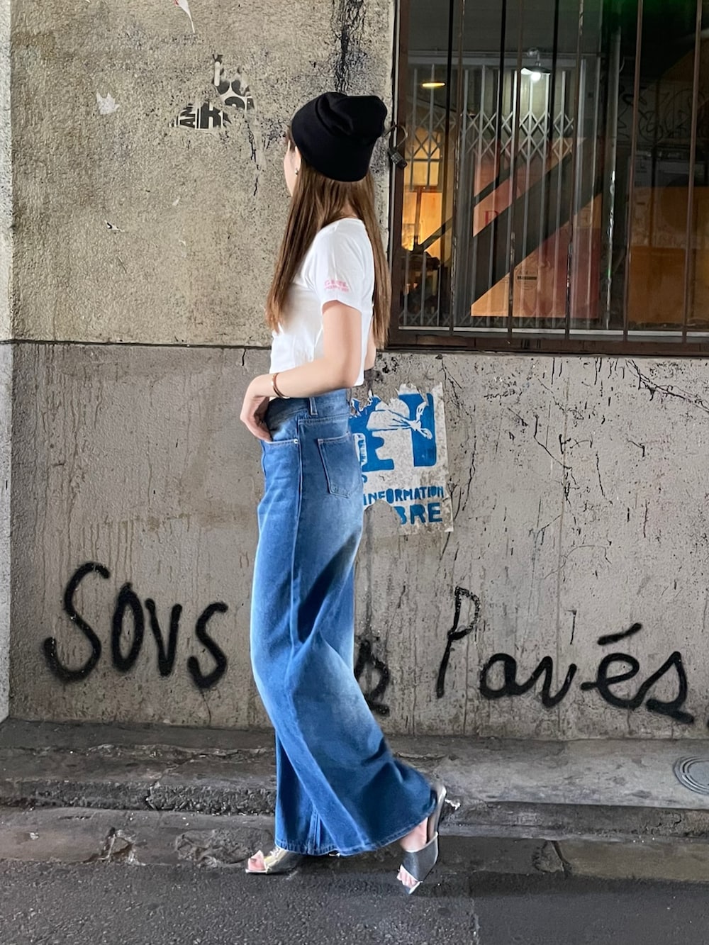 ブルー系のデニムパンツ、シルバー系のサンダル、ホワイト系のTシャツ/カットソーを着用したレディースの夏コーディネートの3枚目の写真