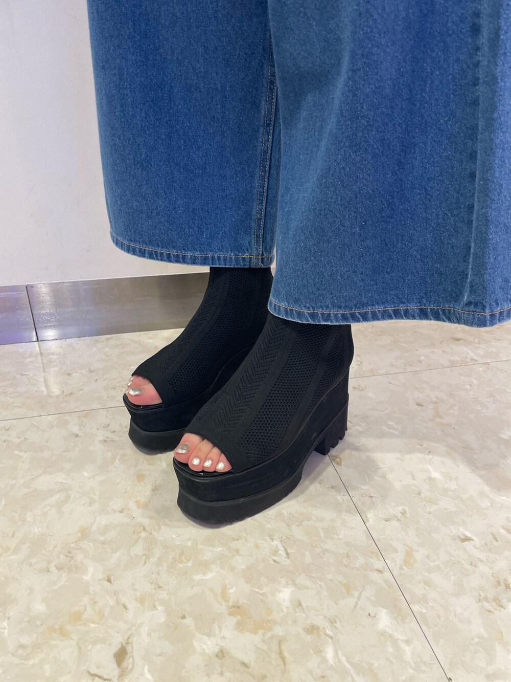 ブルー系のデニムパンツ、ブラック系のブーツ、レッド系のシャツ/ブラウスを着用したレディースの春コーディネートの7枚目の写真