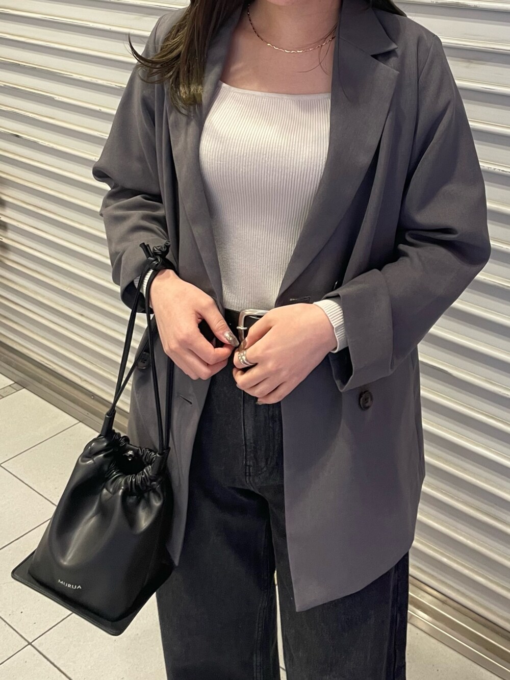 ブラック系のデニムパンツ、グレー系のテーラードジャケット、ホワイト系のニット/セーターを着用したレディースの冬コーディネートの5枚目の写真