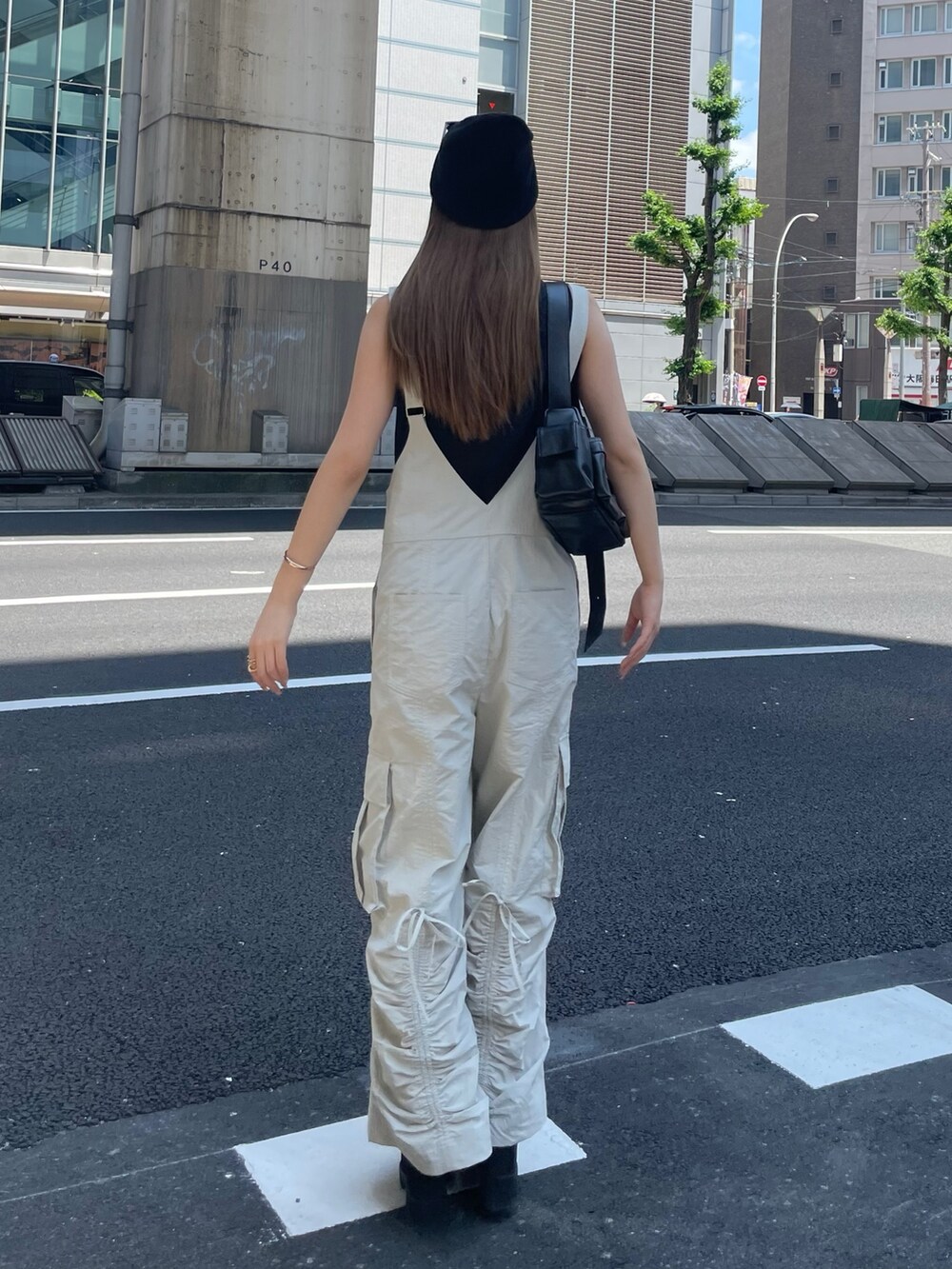 ホワイト系のつなぎ/オールインワン、ブラック系のTシャツ/カットソー、ブラック系のショルダーバッグを着用したレディースの夏コーディネートの4枚目の写真