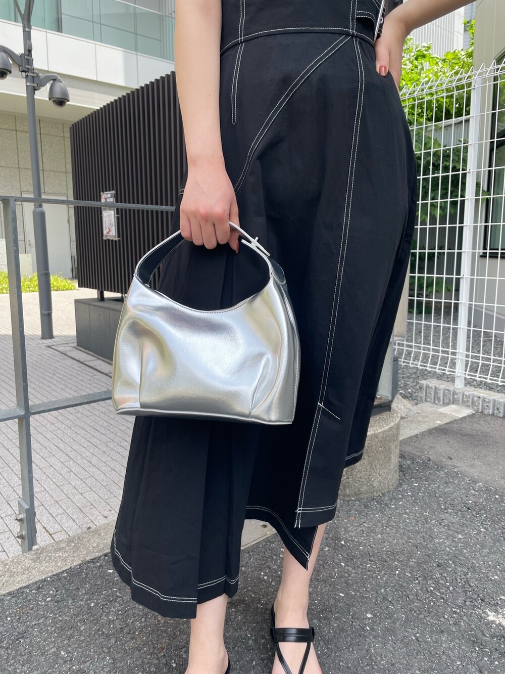 ブラック系のワンピース、ブラック系のニット/セーター、シルバー系のハンドバッグを着用したレディースの春コーディネートの7枚目の写真