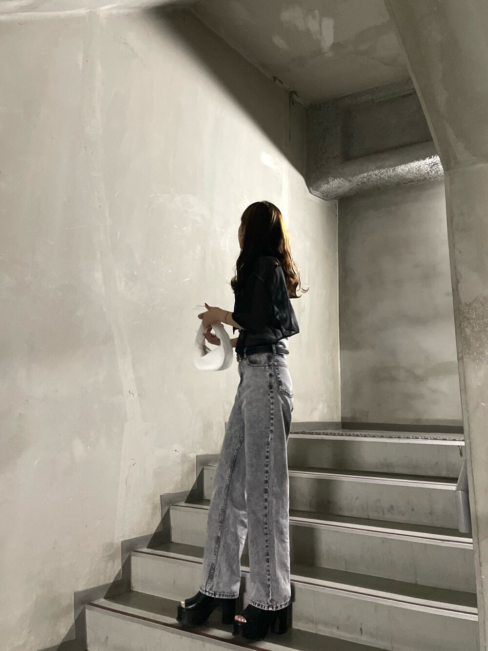 ホワイト系のTシャツ/カットソー、グレー系のデニムパンツ、ブラック系のサンダルを着用したレディースの春コーディネートの3枚目の写真