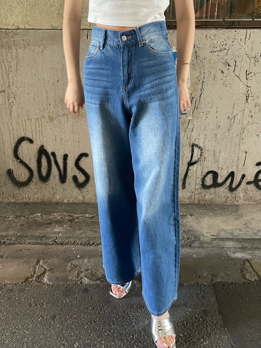 ブルー系のデニムパンツ、シルバー系のサンダル、ホワイト系のTシャツ/カットソーを着用したレディースの夏コーディネートの7枚目の写真