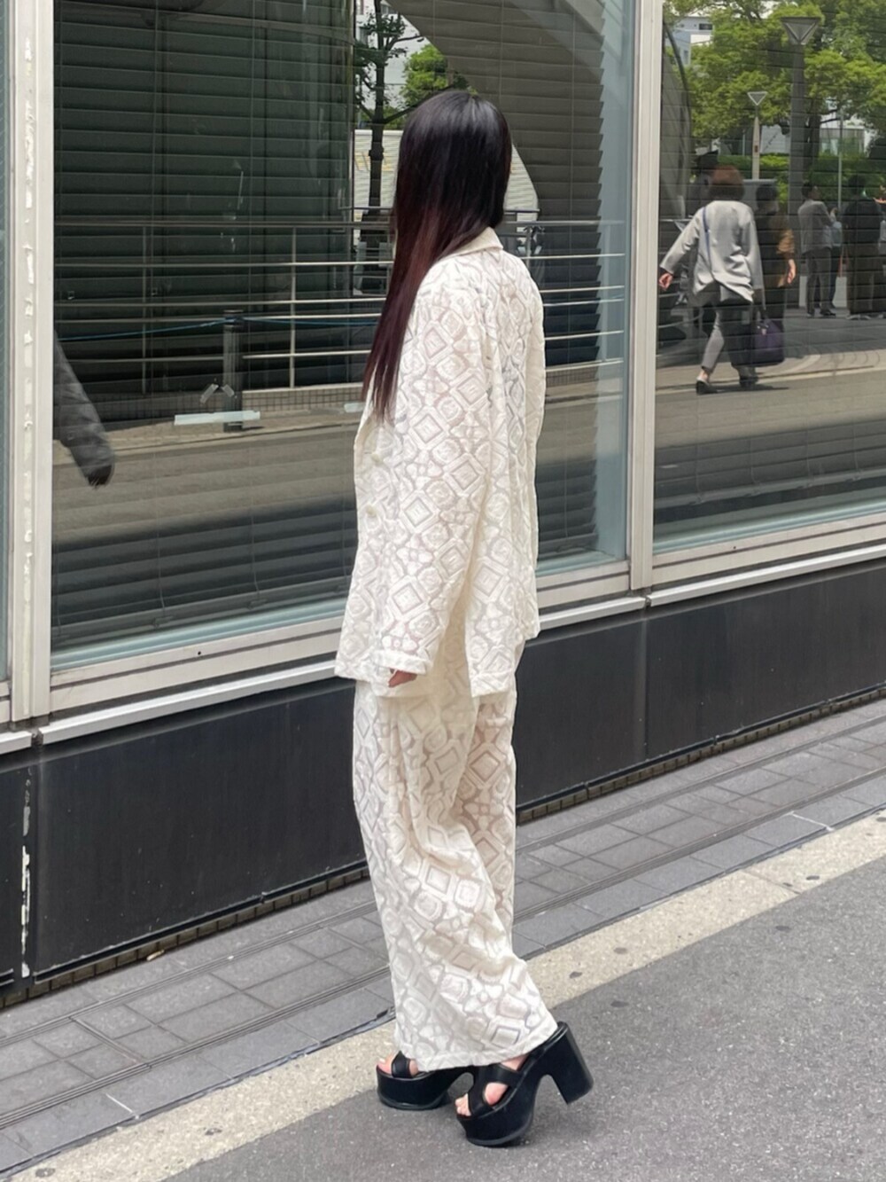 ブラック系のサンダル、ホワイト系のテーラードジャケット、ホワイト系のその他パンツを着用したレディースの春コーディネートの2枚目の写真