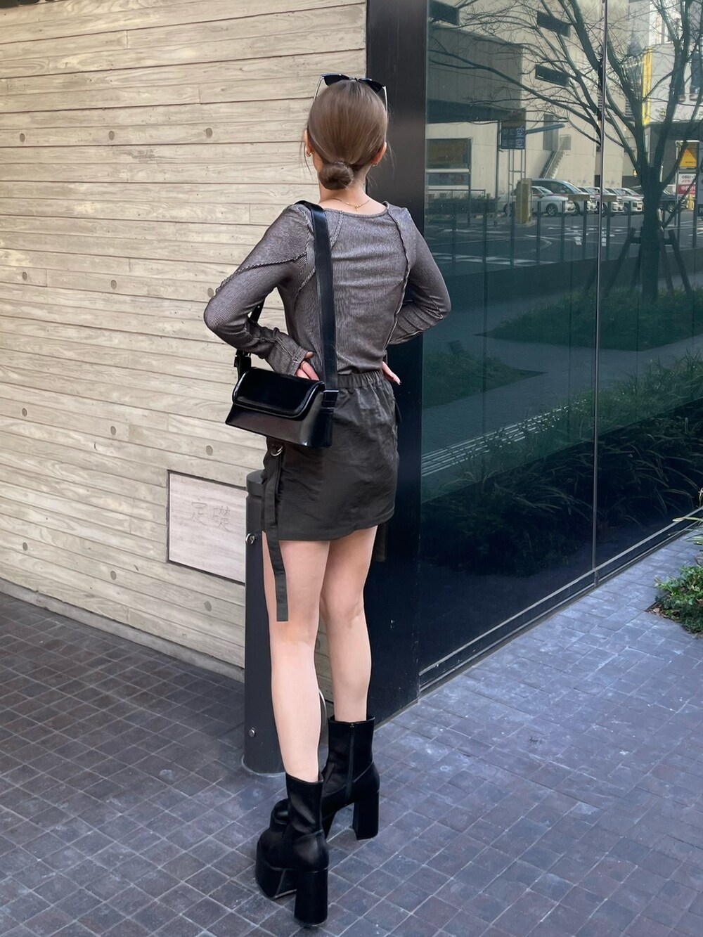 ブラック系のショルダーバッグ、グレー系のTシャツ/カットソー、ベージュ系のスカートを着用したレディースの冬コーディネートの4枚目の写真