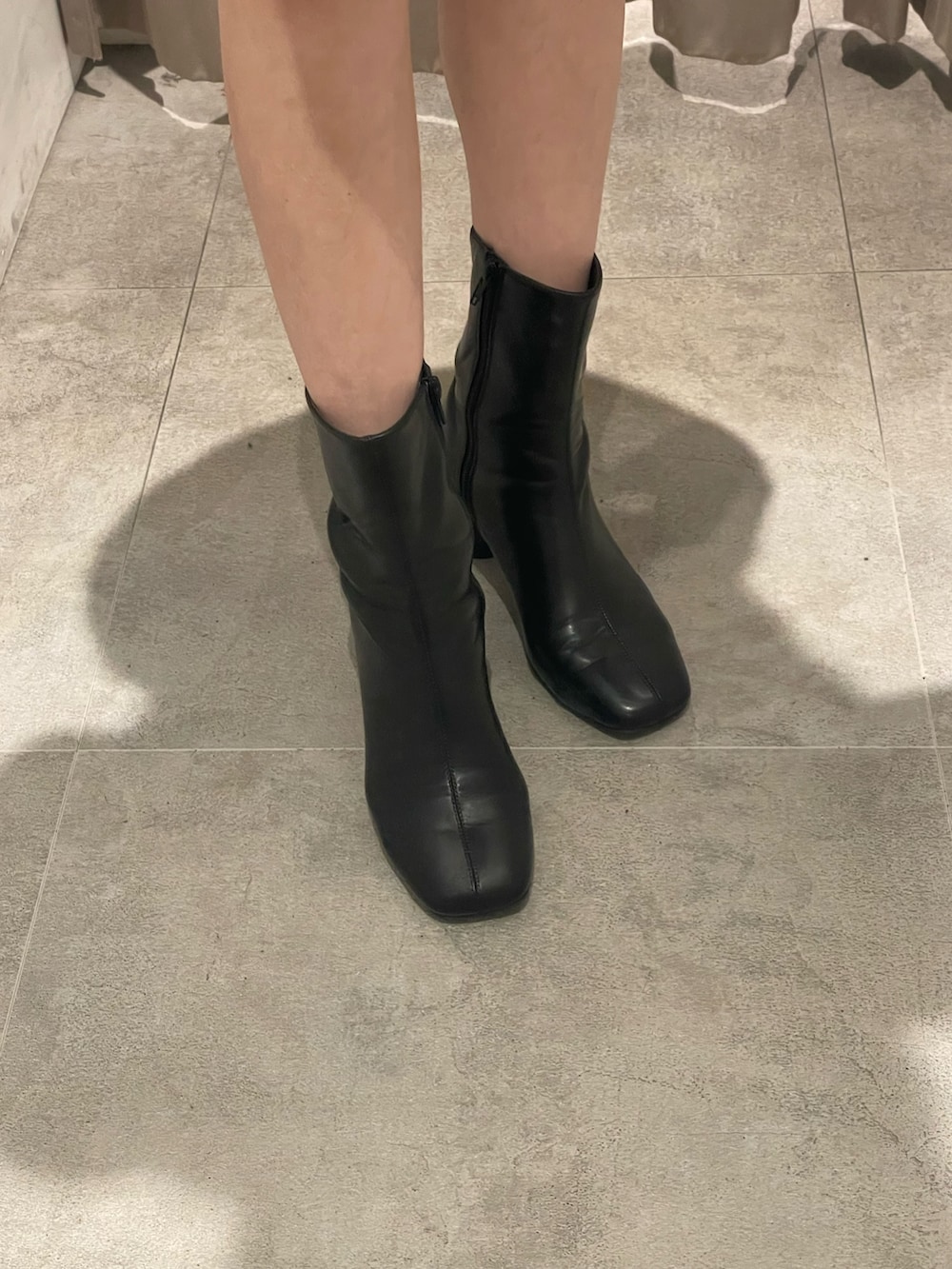 グレー系のスカート、ブラック系のブーツ、グレー系のテーラードジャケットを着用したレディースの秋コーディネートの7枚目の写真