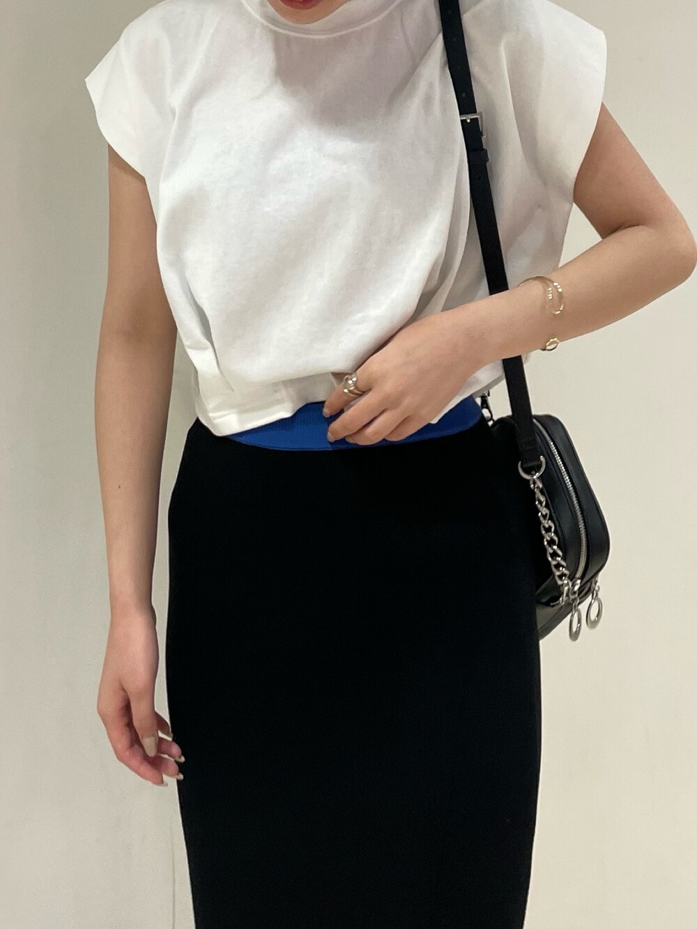 ホワイト系のTシャツ/カットソー、ブラック系のサンダル、ブラック系のショルダーバッグを着用したレディースの春コーディネートの4枚目の写真