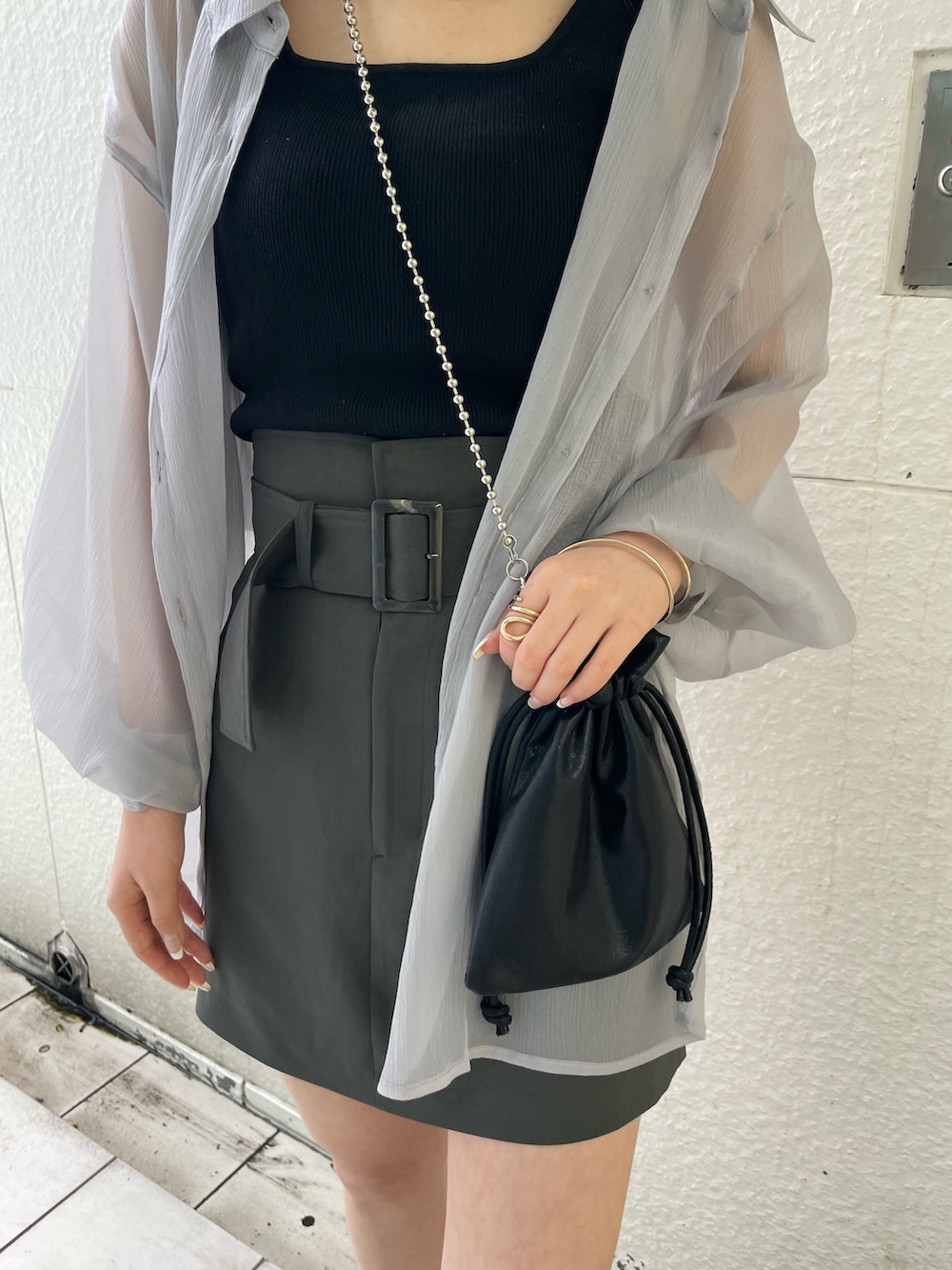 グレー系のシャツ/ブラウス、ブラック系のニット/セーター、グレー系のスカートを着用したレディースの春コーディネートの5枚目の写真