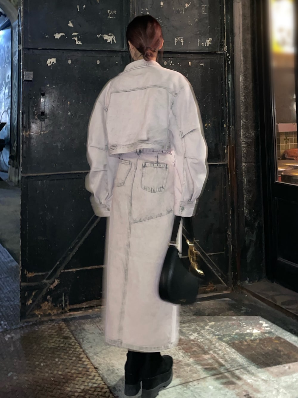 ブラック系のブーツ、ピンク系のデニムジャケット、ピンク系のデニムスカートを着用したレディースの冬コーディネートの3枚目の写真