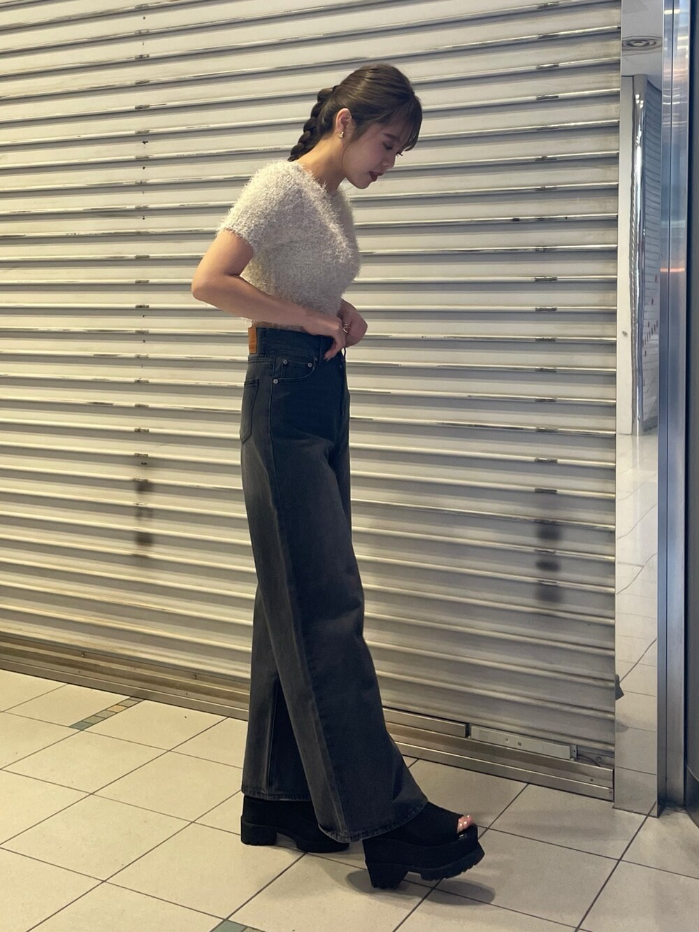 ホワイト系のニット/セーター、ブラック系のデニムパンツ、ブラック系のブーツを着用したレディースの春コーディネートの2枚目の写真