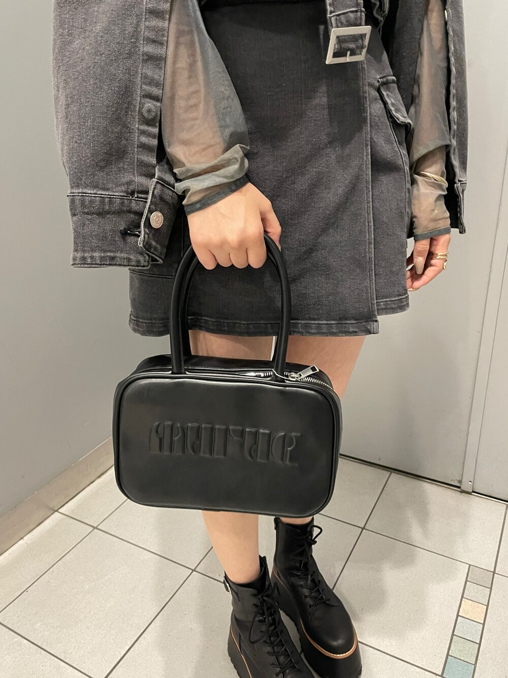 ブラック系のブーツ、ブラック系のスカート、その他のTシャツ/カットソーを着用したレディースの夏コーディネートの8枚目の写真