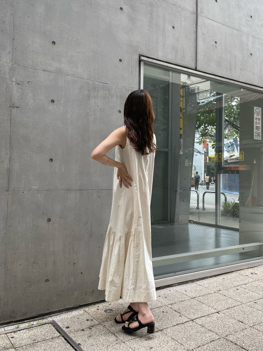 ホワイト系のワンピース、ホワイト系のハンドバッグ、ブラック系のサンダルを着用したレディースの夏コーディネートの3枚目の写真