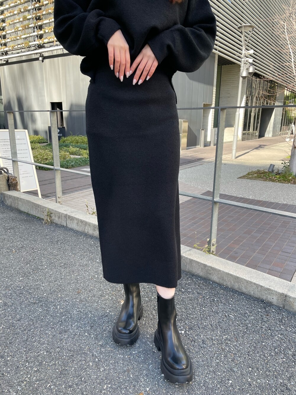 ブラック系のニット/セーター、ブラック系のスカート、ブラック系のブーツを着用したレディースの冬コーディネートの6枚目の写真