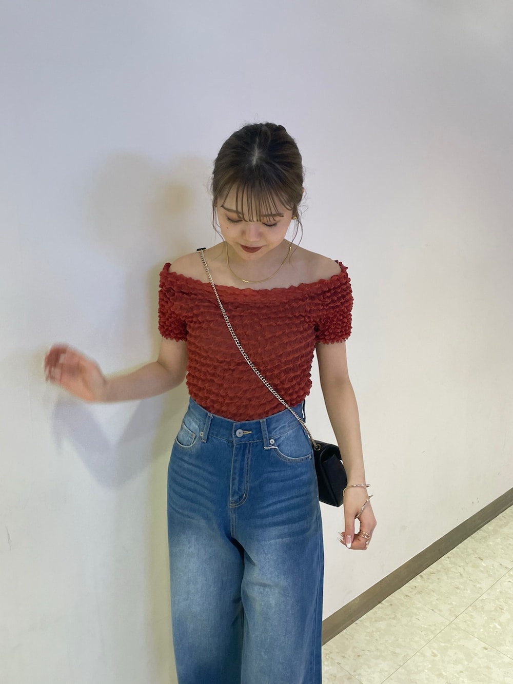 ブルー系のデニムパンツ、ブラック系のブーツ、レッド系のシャツ/ブラウスを着用したレディースの春コーディネートの4枚目の写真