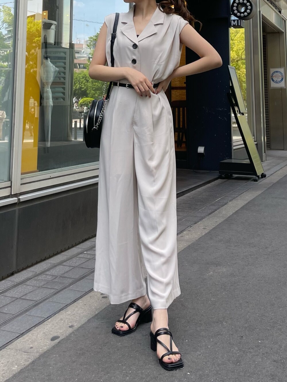 ホワイト系のつなぎ/オールインワン、ブラック系のサンダル、ブラック系のショルダーバッグを着用したレディースの春コーディネートの4枚目の写真