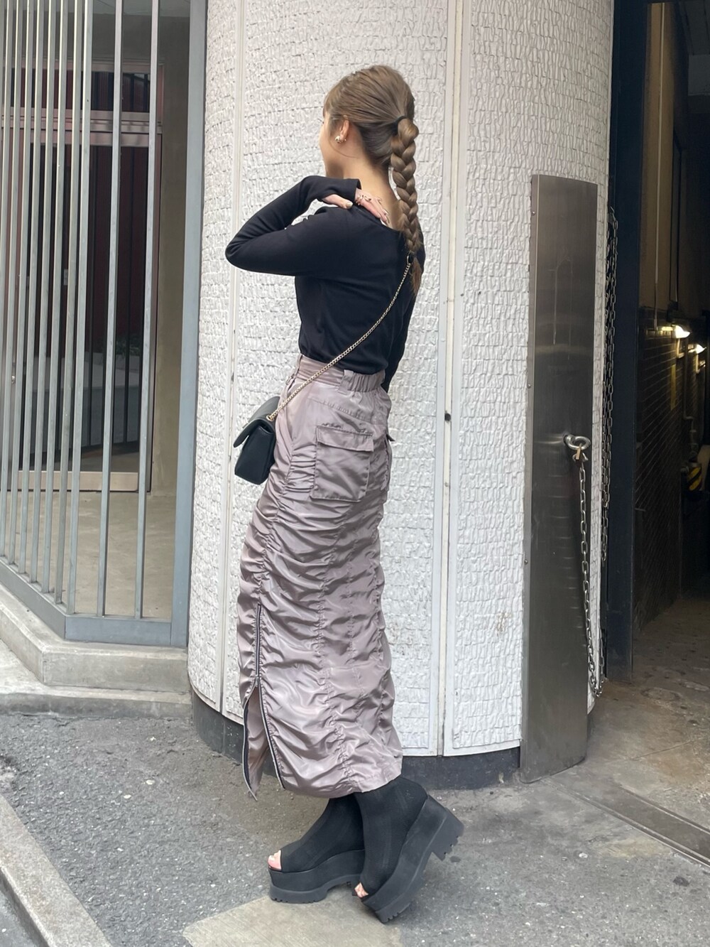 ブラック系のブーツ、グレー系のスカート、ブラック系のTシャツ/カットソーを着用したレディースの春コーディネートの2枚目の写真