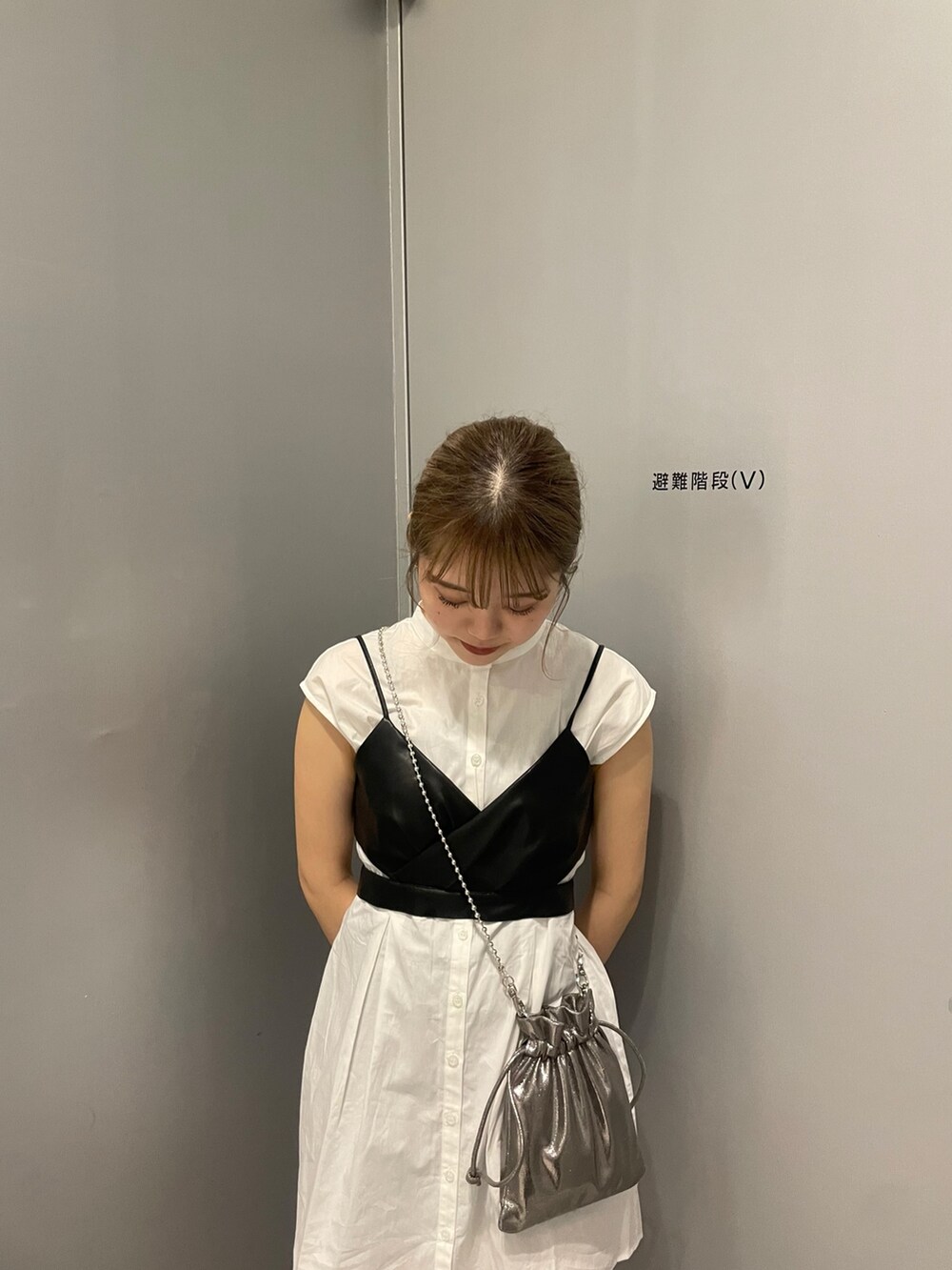 グレー系のショルダーバッグ、ブラック系のブーツ、ブラック系のワンピースを着用したレディースの春コーディネートの5枚目の写真