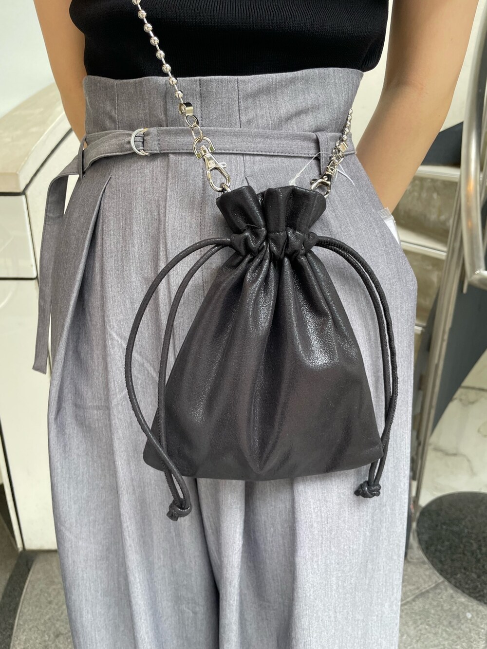 ブラック系のニット/セーター、ブラック系のショルダーバッグ、グレー系のその他パンツを着用したレディースの春コーディネートの8枚目の写真