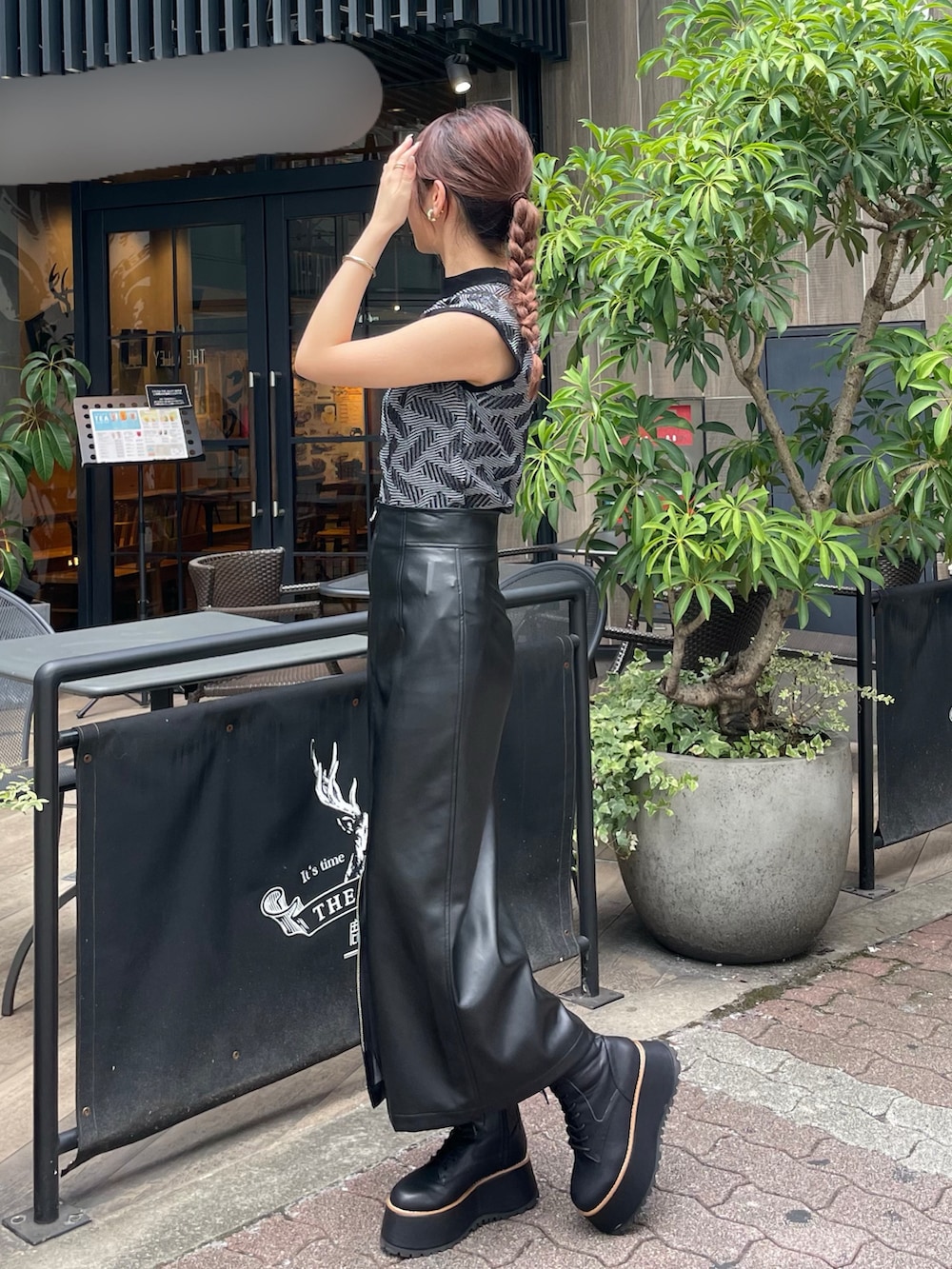 ブラック系のニット/セーター、ブラック系のスカート、ブラック系のブーツを着用したレディースの秋コーディネートの2枚目の写真