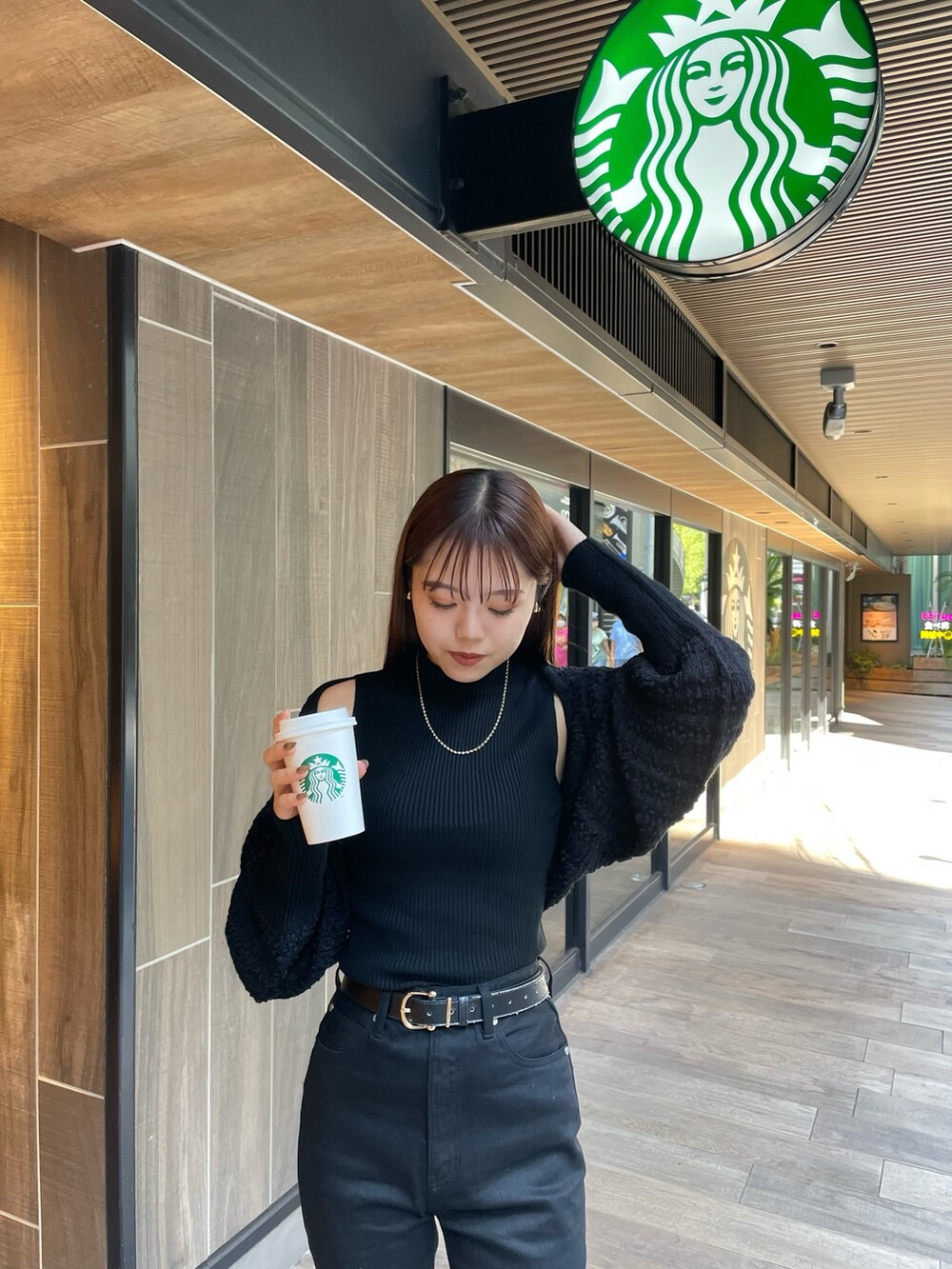 ブラック系のデニムパンツ、ブラック系のカーディガン/ボレロ、ブラック系のブーツを着用したレディースの秋コーディネートの4枚目の写真