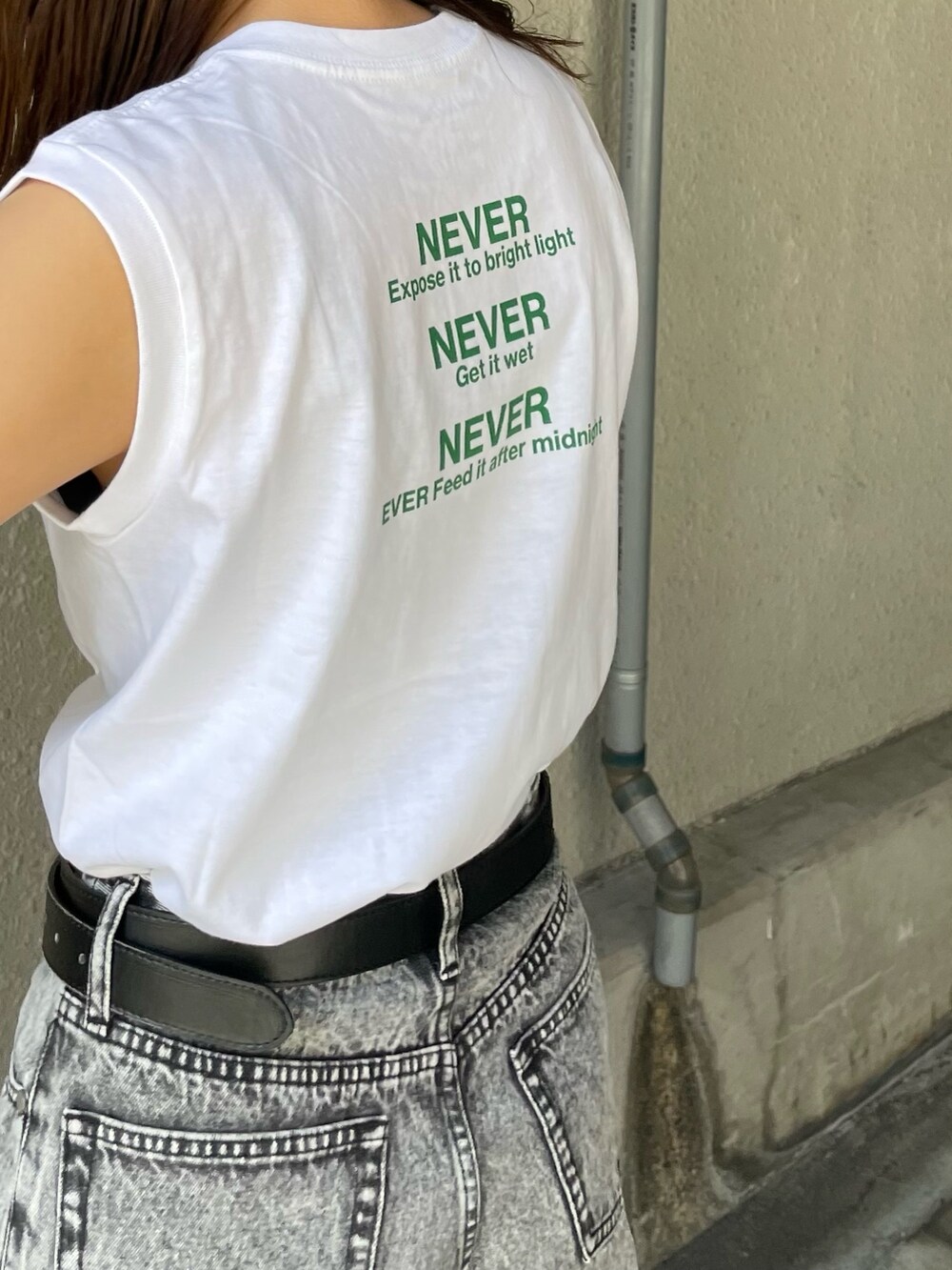 ホワイト系のタンクトップ、シルバー系のハンドバッグ、ブラック系のサンダルを着用したレディースの春コーディネートの5枚目の写真