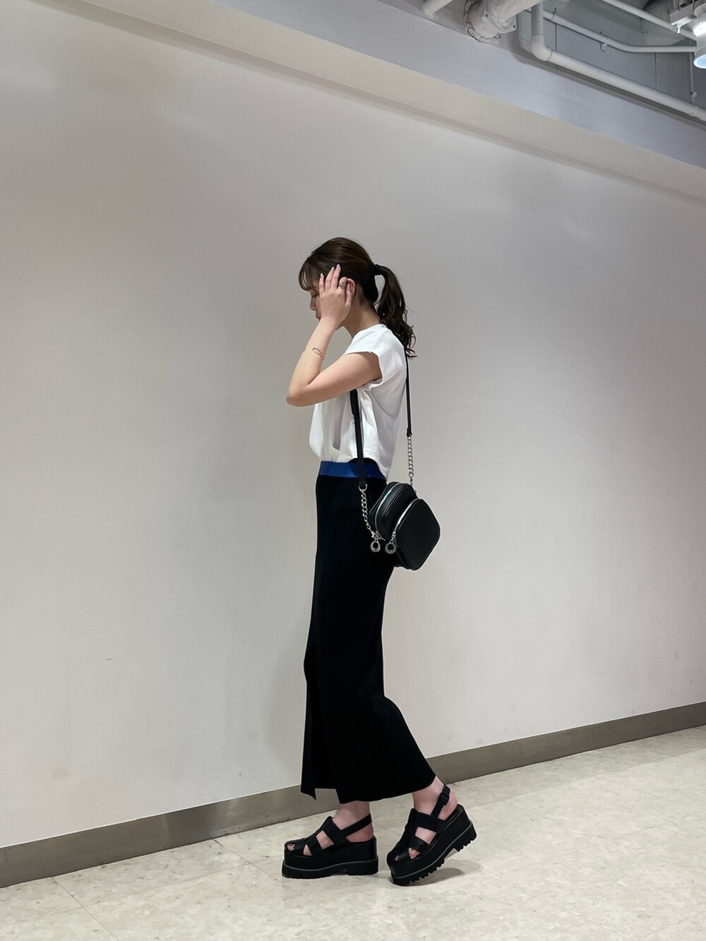 ホワイト系のTシャツ/カットソー、ブラック系のサンダル、ブラック系のショルダーバッグを着用したレディースの春コーディネートの2枚目の写真