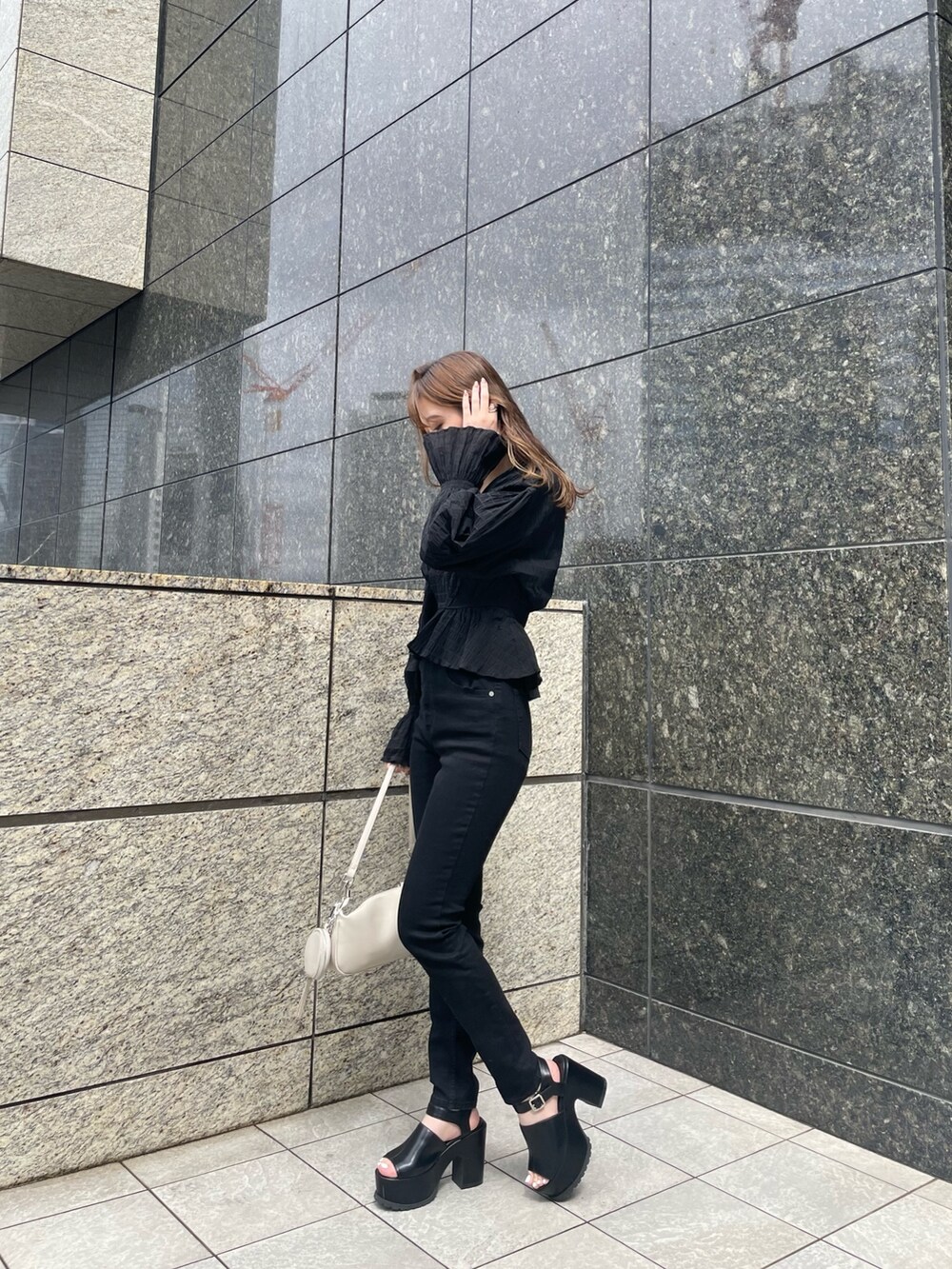 ブラック系のデニムパンツ、ブラック系のサンダル、ブラック系のシャツ/ブラウスを着用したレディースの春コーディネートの2枚目の写真