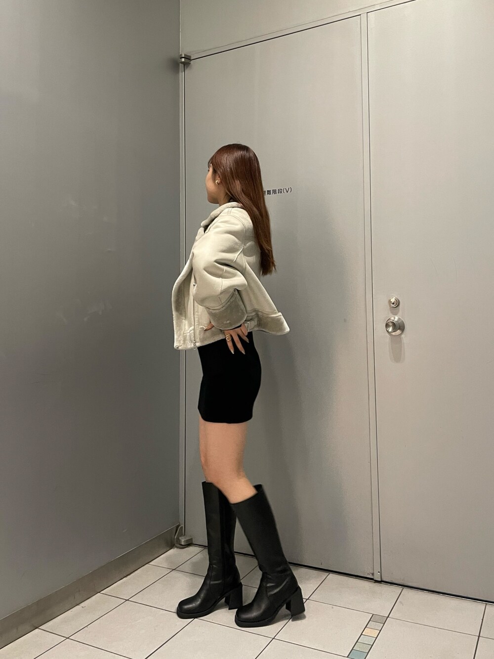 ブラック系のブーツ、ブラック系のワンピース、グレー系のムートンコートを着用したレディースの秋コーディネートの3枚目の写真