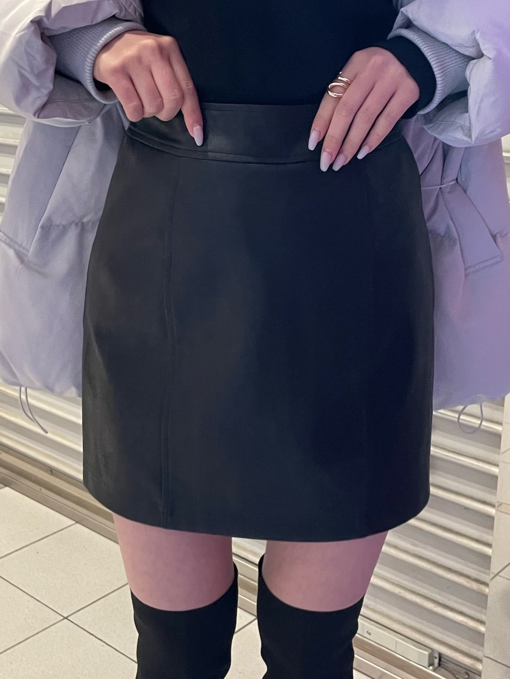 ブラック系のブーツ、ブラック系のニット/セーター、グレー系のダウンジャケット/コートを着用したレディースの冬コーディネートの7枚目の写真