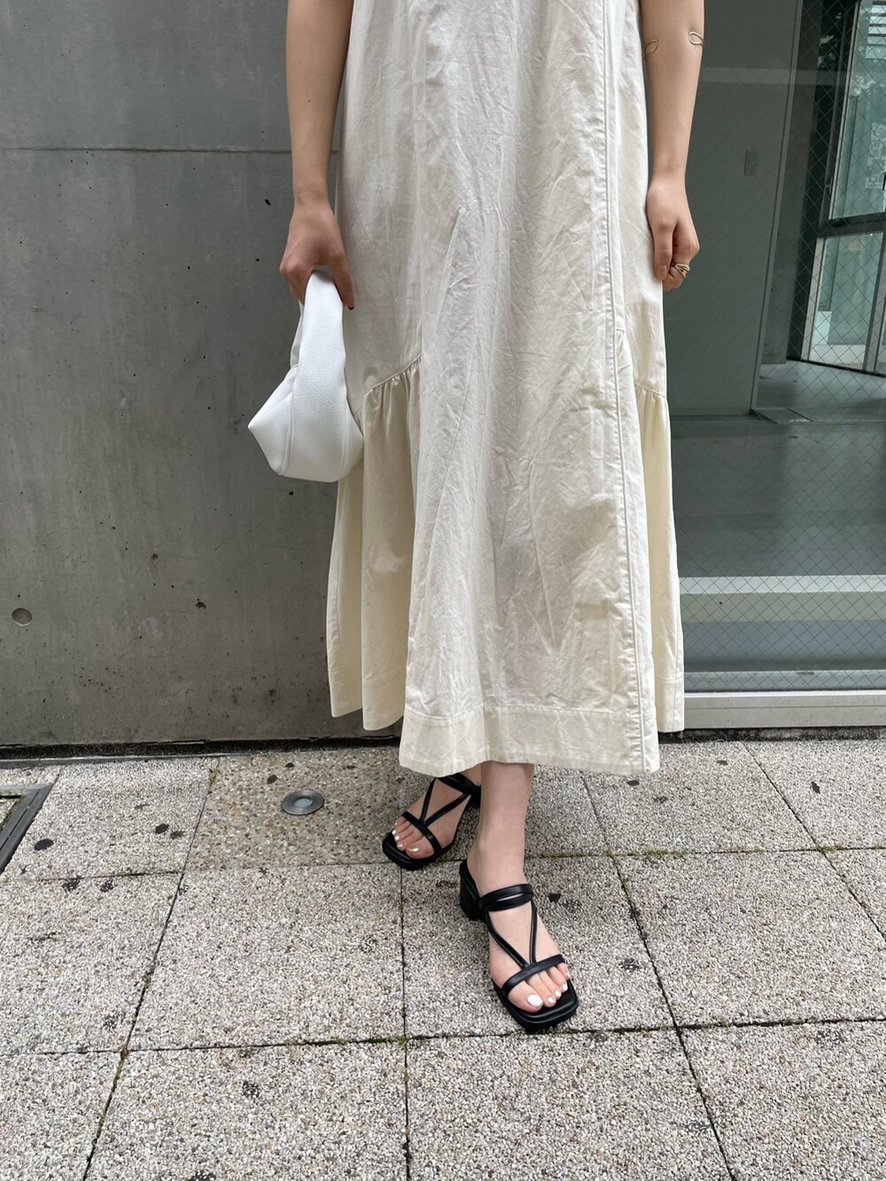 ホワイト系のワンピース、ホワイト系のハンドバッグ、ブラック系のサンダルを着用したレディースの夏コーディネートの8枚目の写真