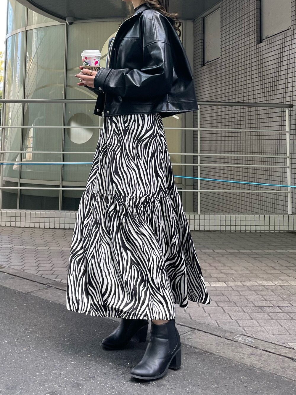 ブラック系のブルゾン、ホワイト系のスカート、ブラック系のニット/セーターを着用したレディースの春コーディネートの5枚目の写真