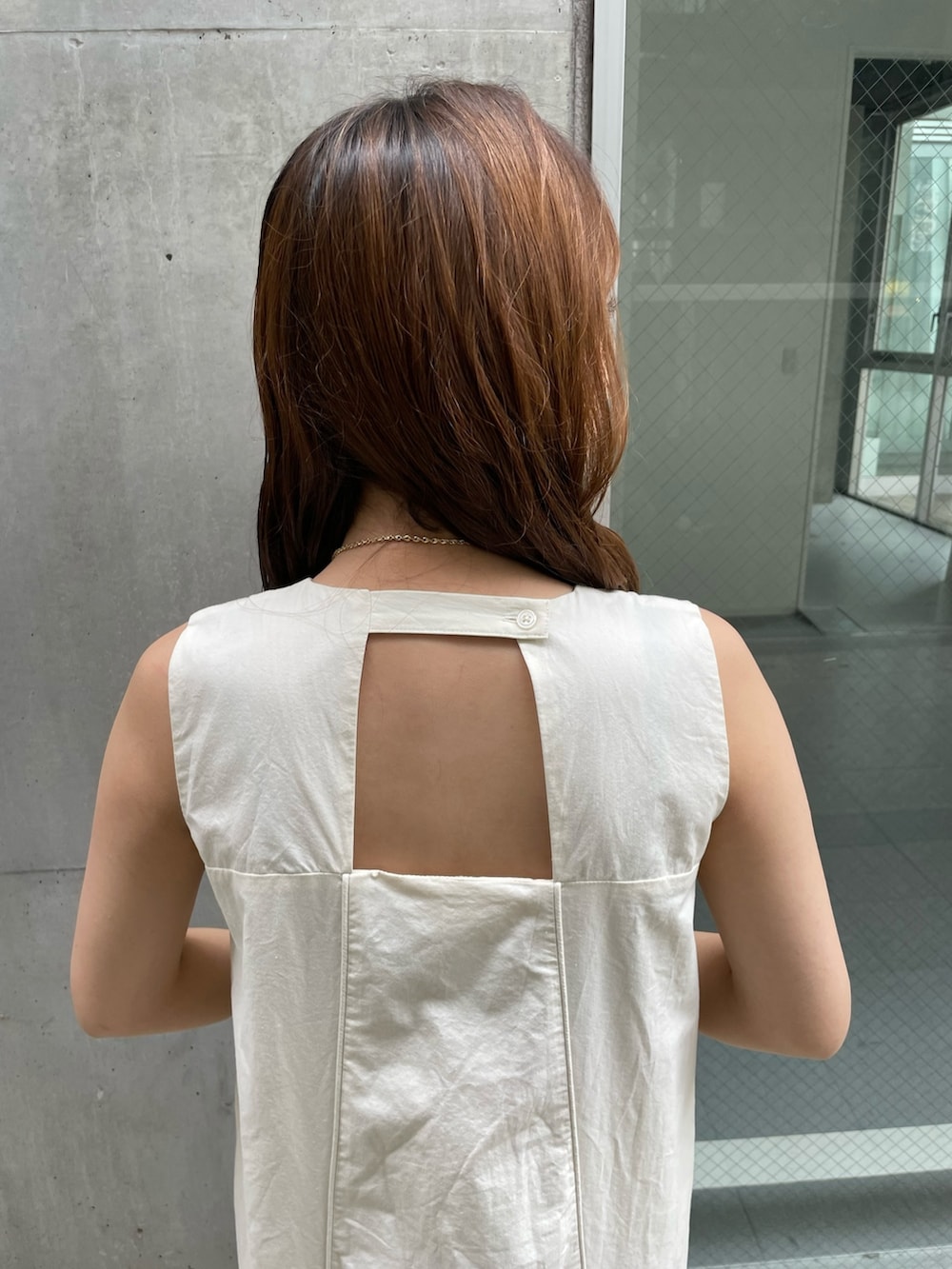 ホワイト系のワンピース、ホワイト系のハンドバッグ、ブラック系のサンダルを着用したレディースの夏コーディネートの7枚目の写真
