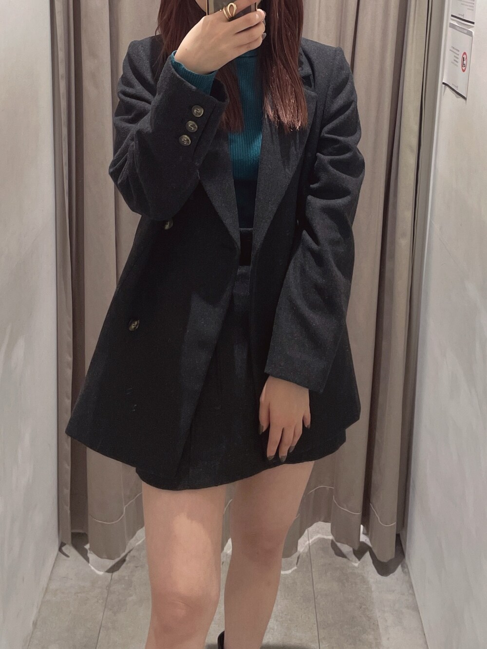 グレー系のスカート、ブラック系のブーツ、グレー系のテーラードジャケットを着用したレディースの秋コーディネートの2枚目の写真