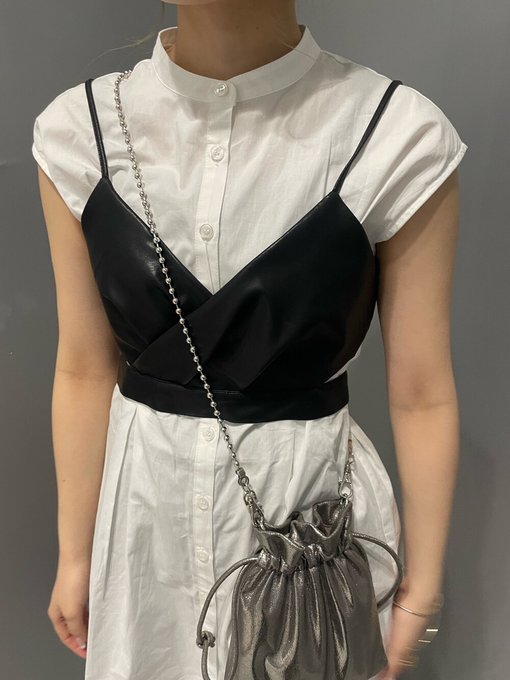 グレー系のショルダーバッグ、ブラック系のブーツ、ブラック系のワンピースを着用したレディースの春コーディネートの6枚目の写真