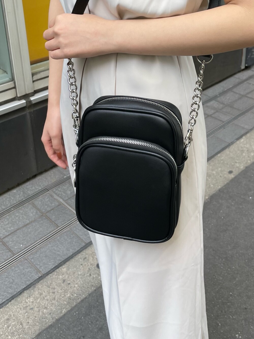 ホワイト系のつなぎ/オールインワン、ブラック系のサンダル、ブラック系のショルダーバッグを着用したレディースの春コーディネートの7枚目の写真