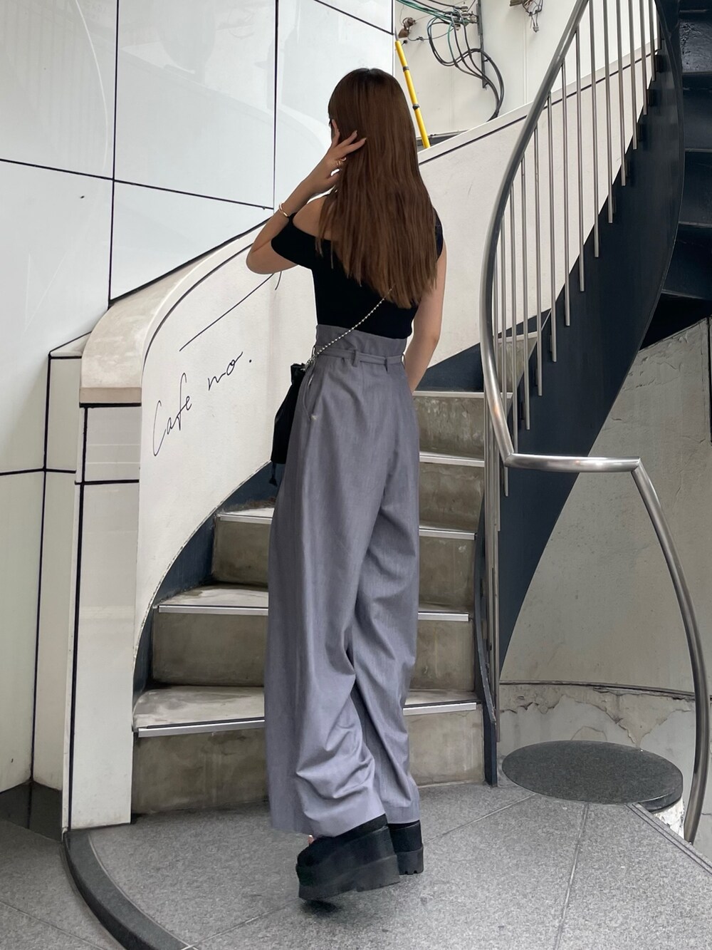 ブラック系のニット/セーター、ブラック系のショルダーバッグ、グレー系のその他パンツを着用したレディースの春コーディネートの3枚目の写真