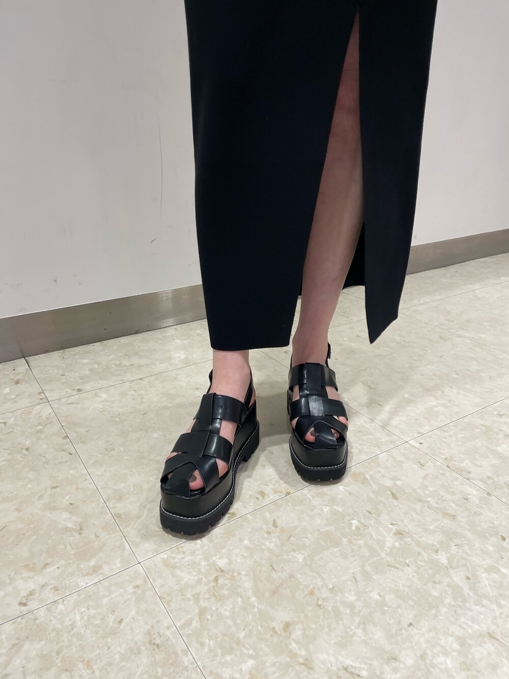 ホワイト系のTシャツ/カットソー、ブラック系のサンダル、ブラック系のショルダーバッグを着用したレディースの春コーディネートの6枚目の写真