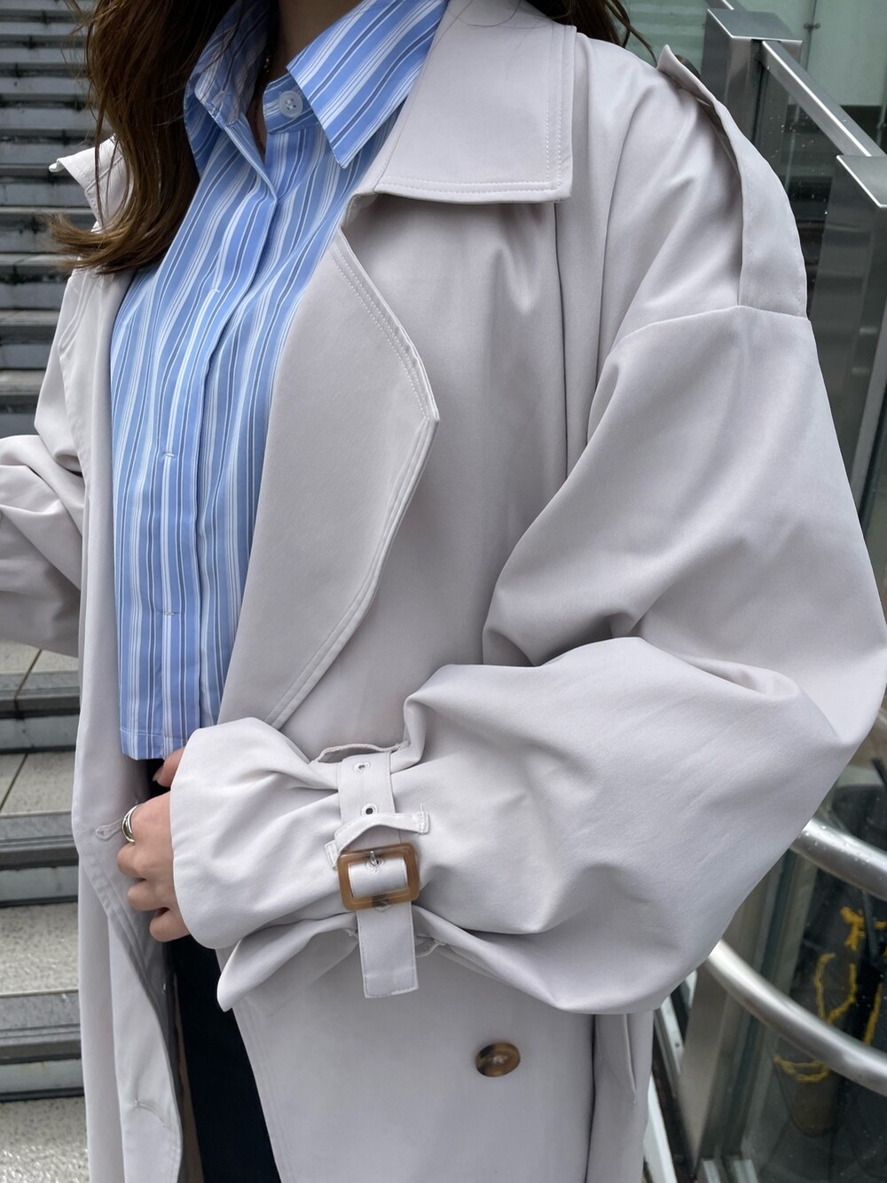 ホワイト系のトレンチコート、ブラック系のサンダル、ブラック系のデニムパンツを着用したレディースの春コーディネートの7枚目の写真