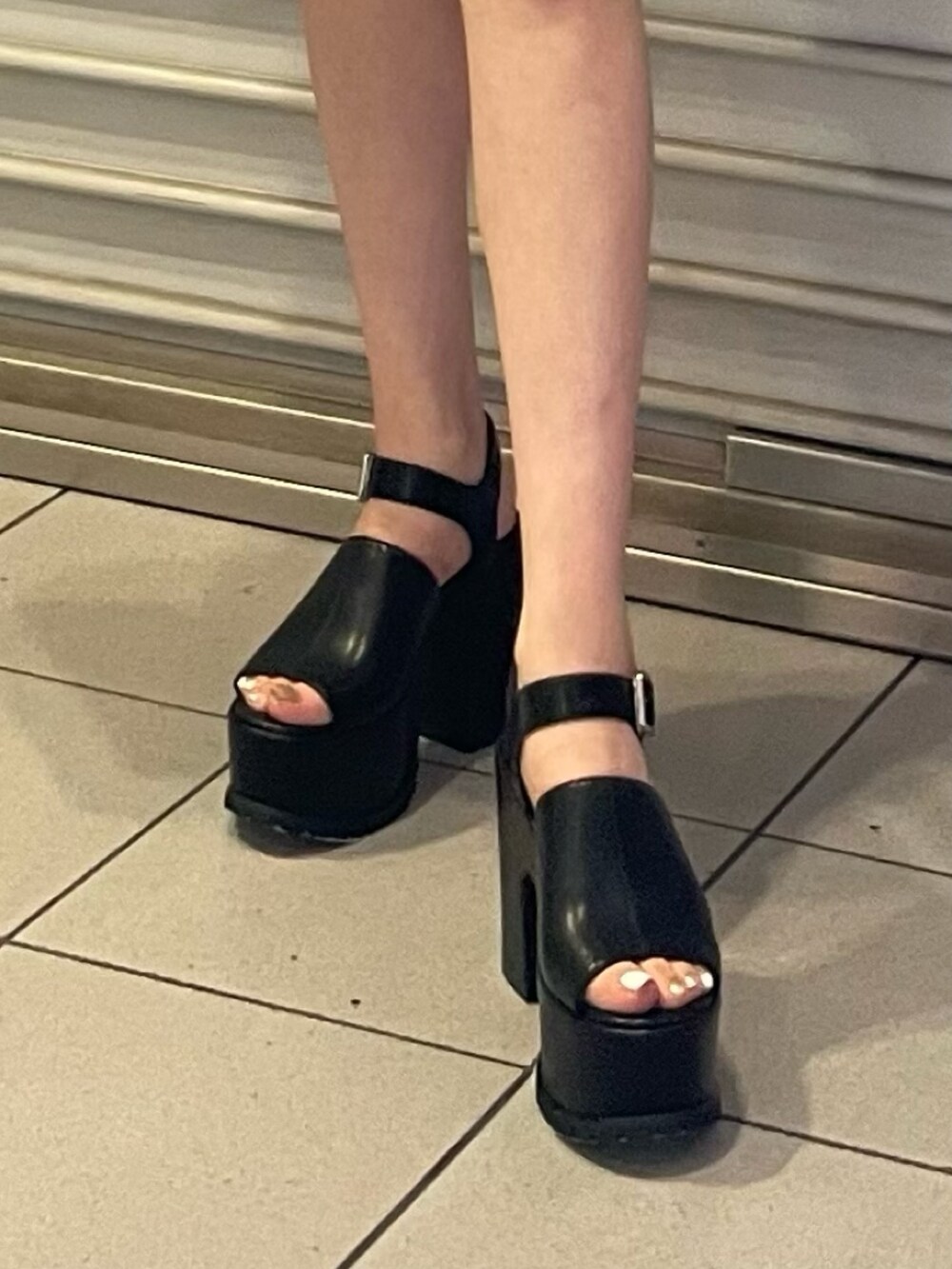 ブラック系のスカート、ホワイト系のタンクトップ、シルバー系のハンドバッグを着用したレディースの夏コーディネートの7枚目の写真