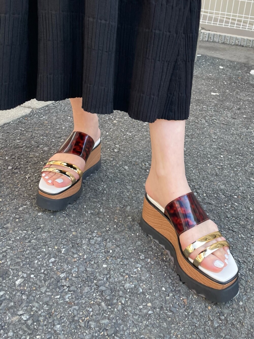 ブラック系のワンピース、シルバー系のハンドバッグ、その他のサンダルを着用したレディースの春コーディネートの7枚目の写真