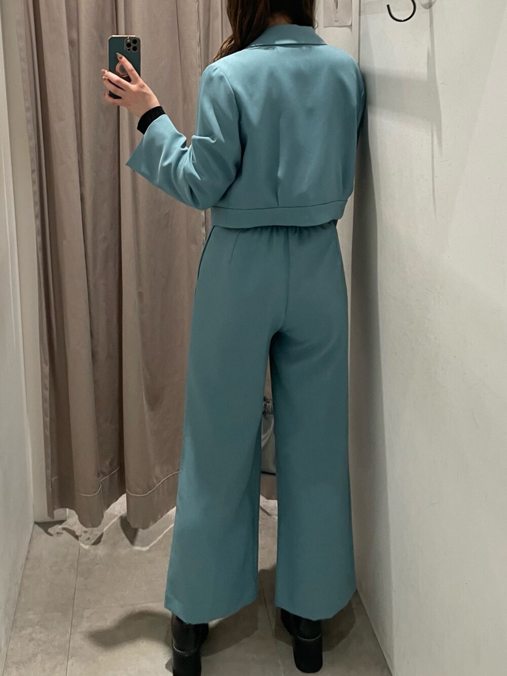 シルバー系のハンドバッグ、ブルー系のテーラードジャケット、ブラック系のニット/セーターを着用したレディースの春コーディネートの3枚目の写真