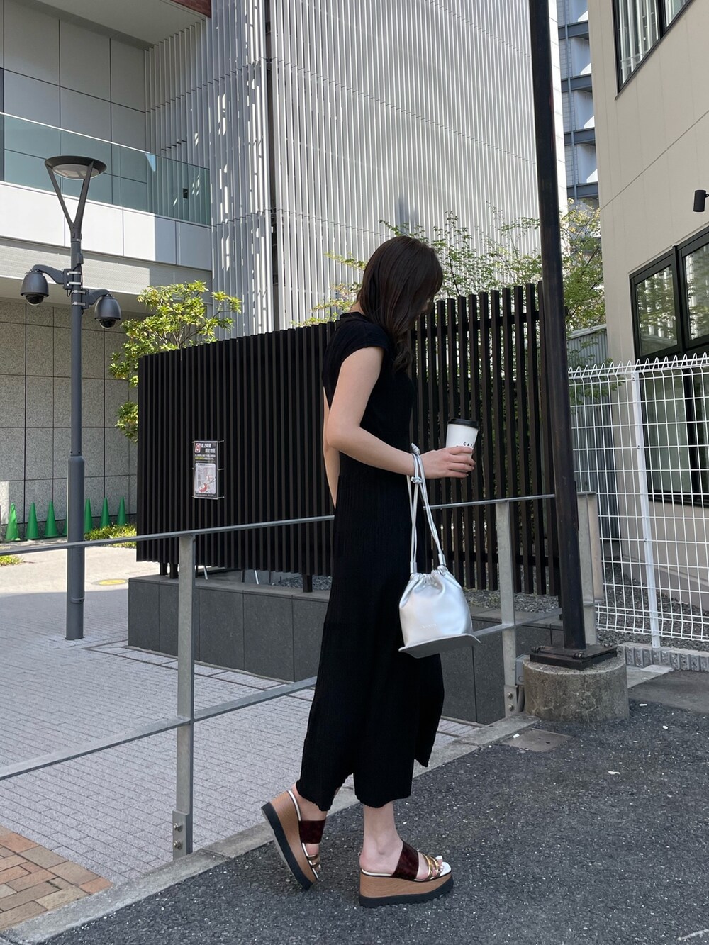 ブラック系のワンピース、シルバー系のハンドバッグ、その他のサンダルを着用したレディースの春コーディネートの3枚目の写真