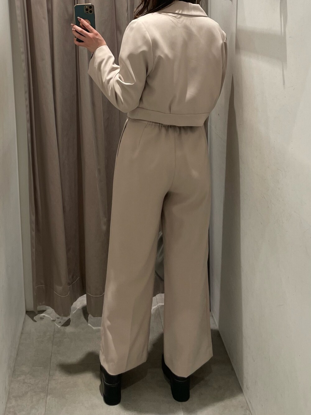 シルバー系のハンドバッグ、ベージュ系のテーラードジャケット、ブラック系のニット/セーターを着用したレディースの春コーディネートの3枚目の写真